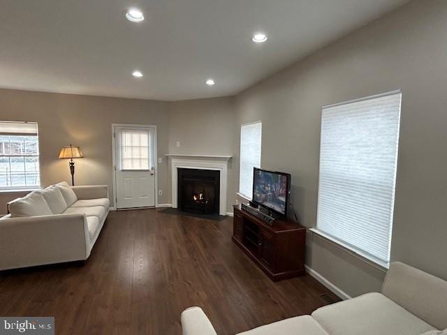 living room with a fireplace with flush hearth, baseboards, dark wood-style flooring, and recessed lighting