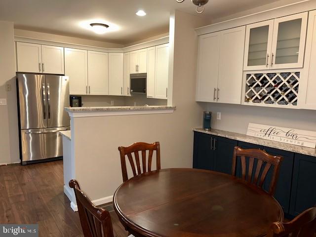 dining area featuring a dry bar, dark wood-type flooring, and recessed lighting