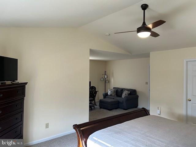 bedroom with a ceiling fan, lofted ceiling, carpet flooring, and baseboards