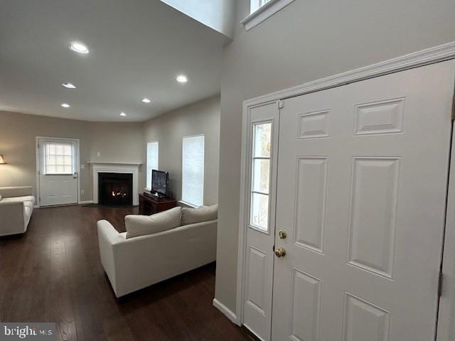 foyer featuring dark wood-style flooring, a fireplace with flush hearth, and recessed lighting