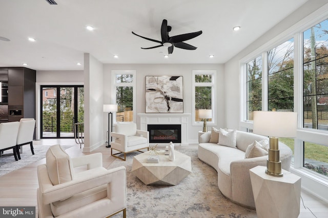 living room with a wealth of natural light, a glass covered fireplace, and recessed lighting