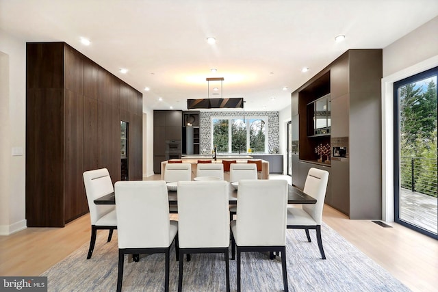 dining space featuring light wood finished floors and recessed lighting