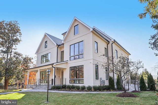 modern farmhouse style home featuring stucco siding and a front yard