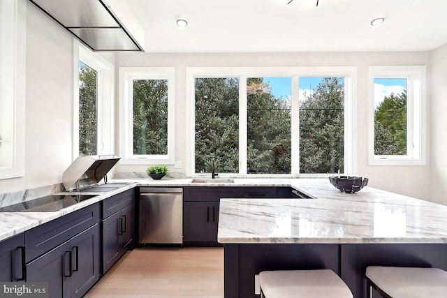 kitchen featuring a breakfast bar, dishwasher, black electric stovetop, and light stone countertops