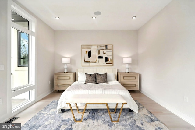 bedroom featuring recessed lighting, light wood-type flooring, visible vents, and baseboards