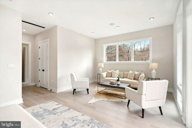 living room with light wood finished floors, recessed lighting, and baseboards