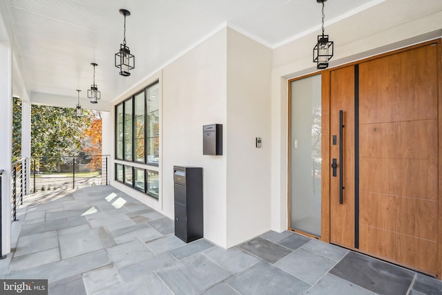 view of exterior entry with a porch and stucco siding