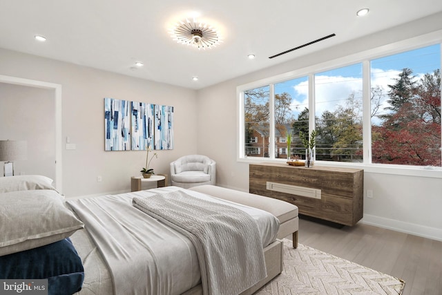 bedroom with light wood finished floors, baseboards, and recessed lighting