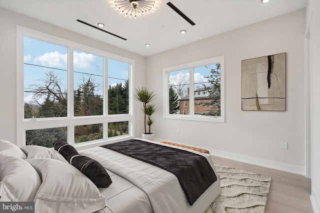 bedroom with baseboards, wood finished floors, and recessed lighting