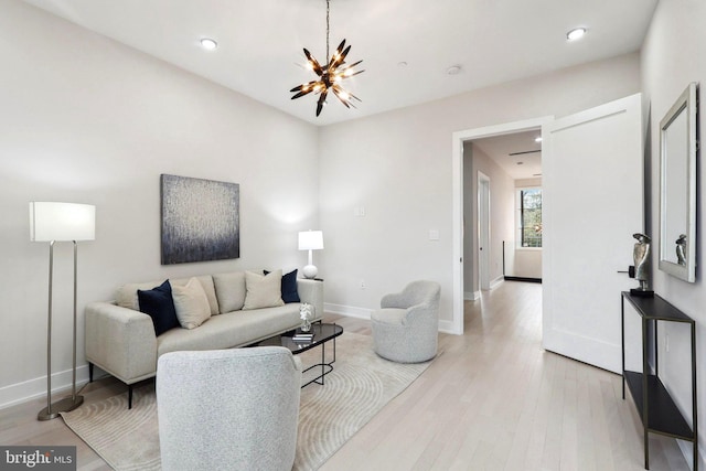 living room with baseboards, light wood finished floors, recessed lighting, and a notable chandelier