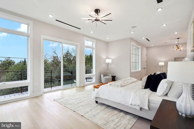 bedroom featuring a chandelier, access to outside, and multiple windows