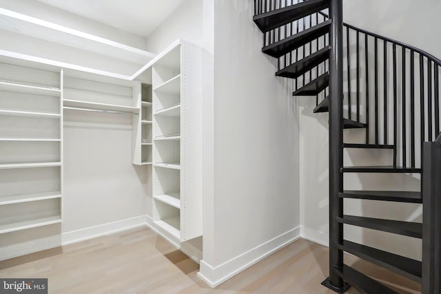 staircase with baseboards and wood finished floors