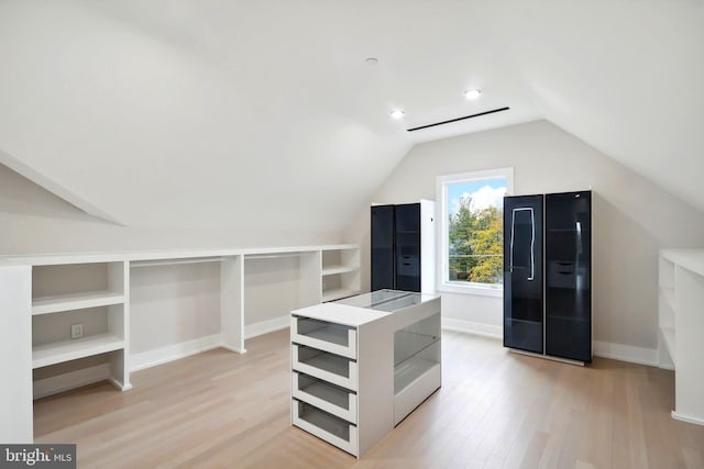 spacious closet with lofted ceiling and light wood-style flooring