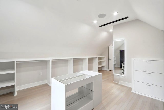 bonus room featuring light wood-style flooring, baseboards, and vaulted ceiling