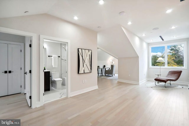 additional living space featuring lofted ceiling, light wood finished floors, and baseboards