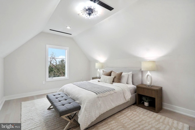 bedroom with visible vents, baseboards, vaulted ceiling, and wood finished floors