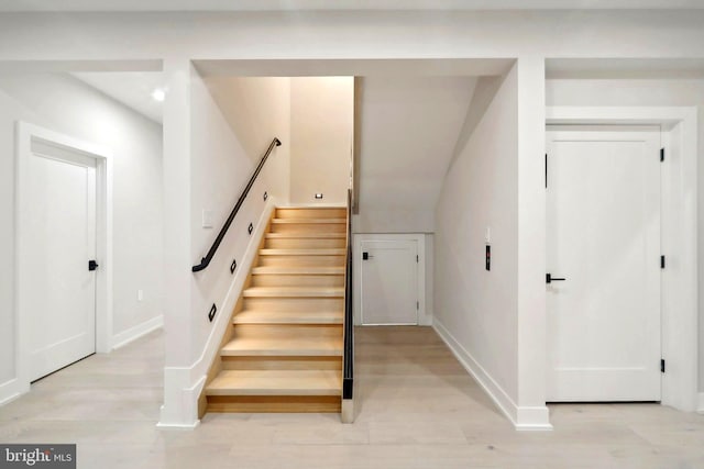 stairway featuring baseboards and wood finished floors