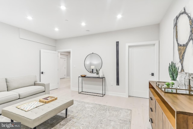 living area featuring baseboards, light wood finished floors, and recessed lighting