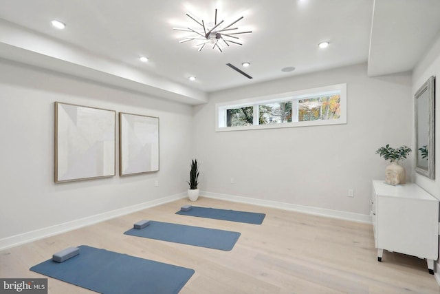 workout area with light wood finished floors, baseboards, a chandelier, and recessed lighting