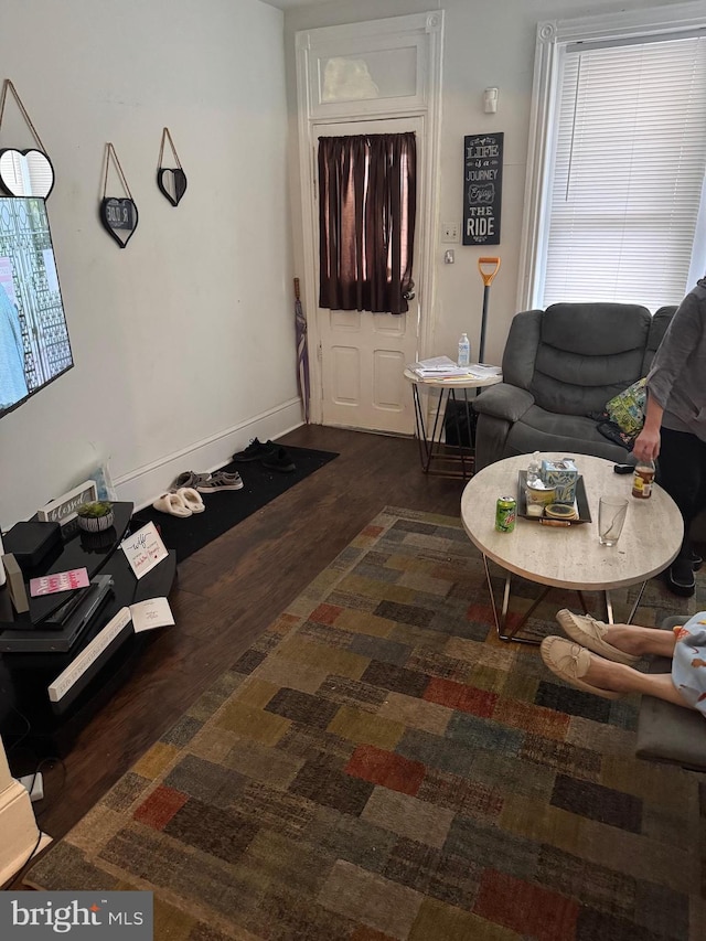 living area featuring dark wood-type flooring and baseboards