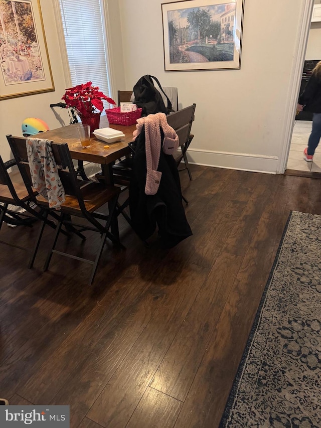 dining room with wood-type flooring and baseboards