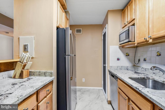 kitchen featuring visible vents, appliances with stainless steel finishes, light stone countertops, marble finish floor, and a sink