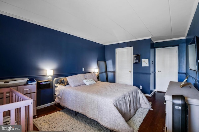 bedroom featuring baseboards, wood finished floors, and crown molding