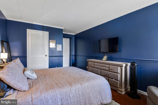 bedroom with crown molding and wood finished floors