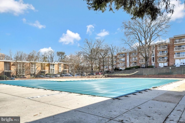 community pool with fence and a patio