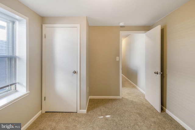 unfurnished bedroom with baseboards and carpet