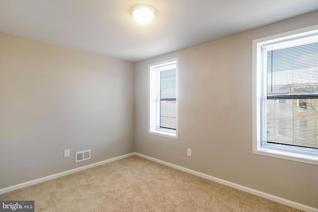 unfurnished room featuring visible vents, carpet flooring, and baseboards