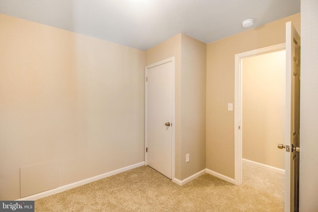 interior space featuring light colored carpet and baseboards