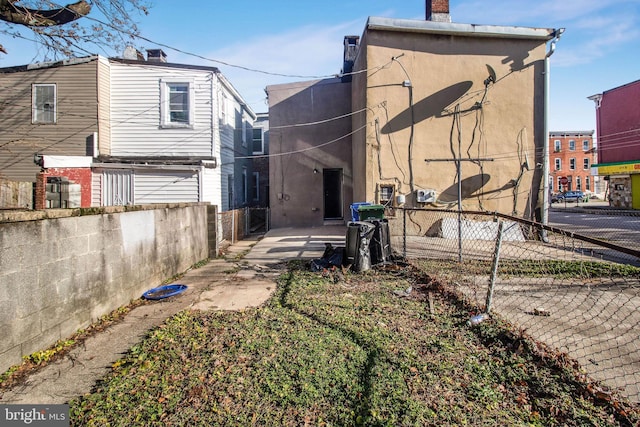 rear view of property featuring fence and stucco siding