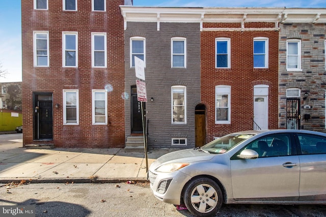 townhome / multi-family property featuring entry steps and brick siding