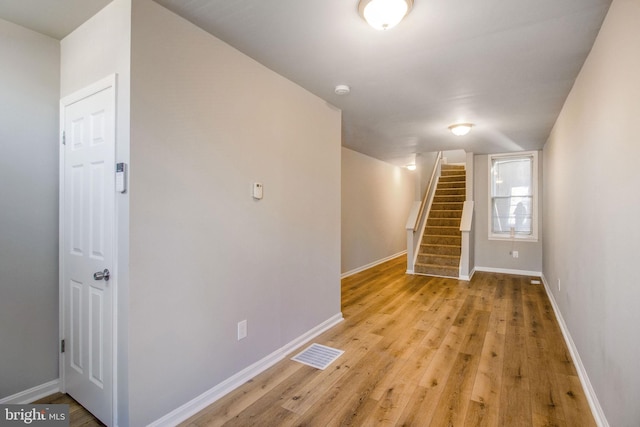 interior space with stairs, baseboards, visible vents, and light wood-type flooring