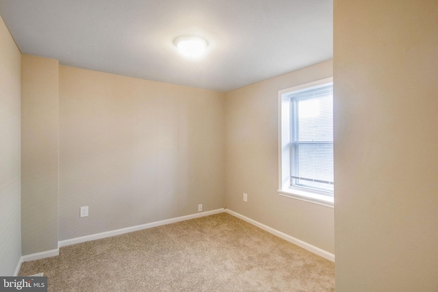 carpeted spare room with baseboards