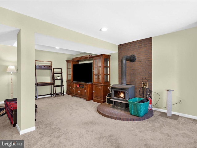 living area featuring a wood stove, carpet flooring, recessed lighting, and baseboards