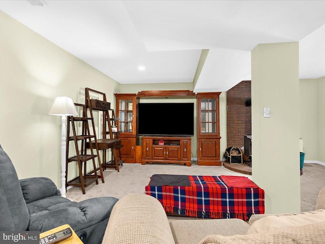 living area featuring a wood stove, baseboards, and carpet flooring