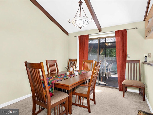 dining space with lofted ceiling with beams, baseboards, and light colored carpet