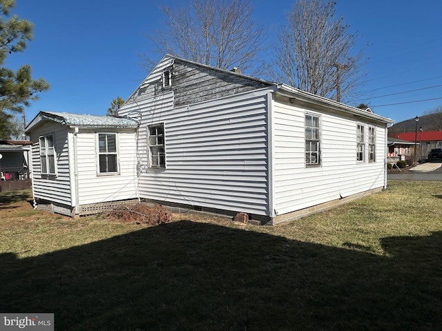 view of side of home with a yard