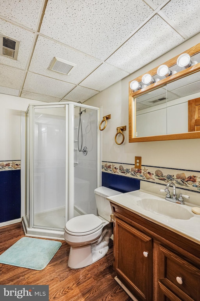 full bath with visible vents, a shower stall, vanity, and wood finished floors