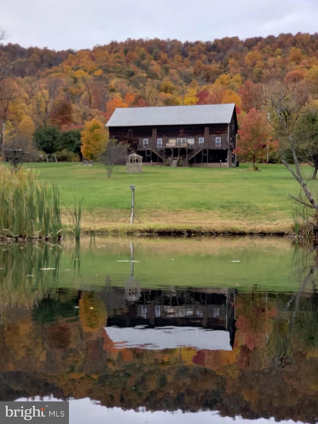 surrounding community featuring a yard, a water view, and a wooded view