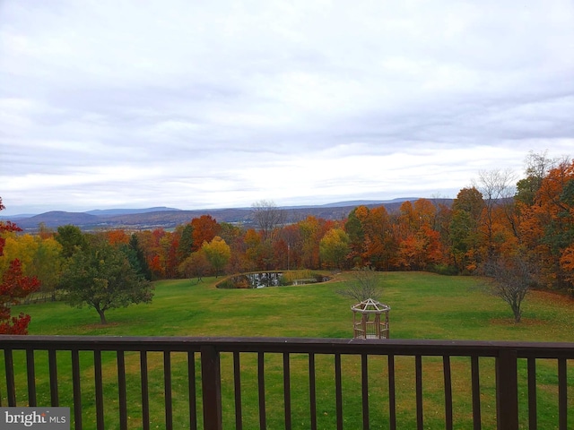 view of yard featuring a forest view and a mountain view