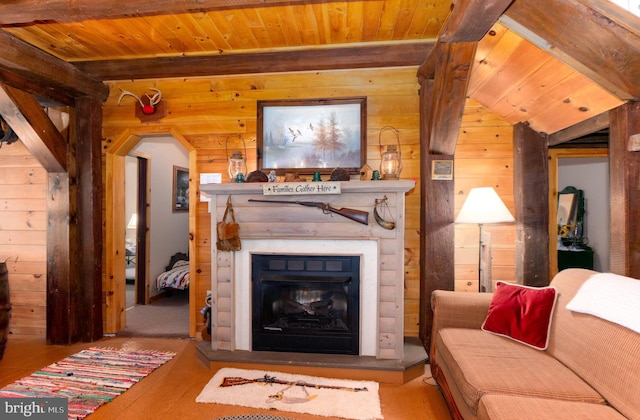 living room featuring a glass covered fireplace, wooden ceiling, wood walls, and beam ceiling