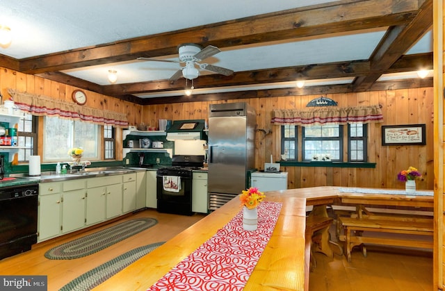 kitchen with butcher block counters, beamed ceiling, wooden walls, and black appliances