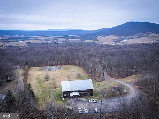 birds eye view of property with a mountain view and a forest view