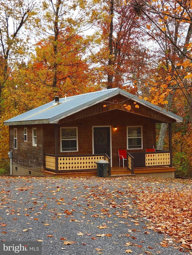 chalet / cabin featuring a porch, crawl space, and metal roof