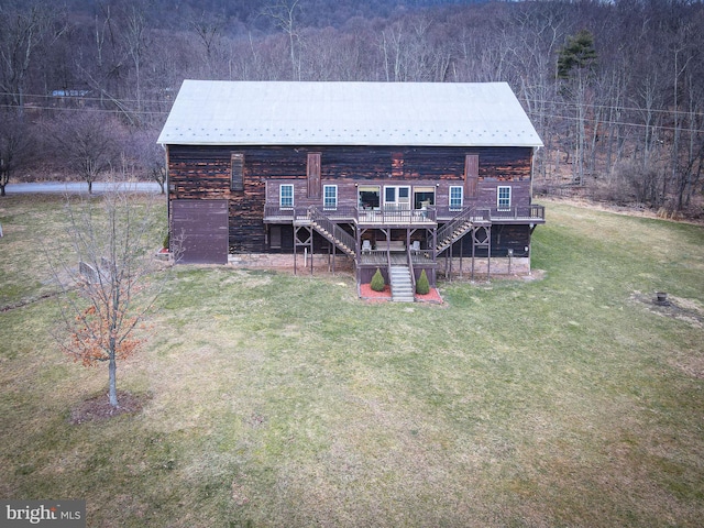 back of house with a deck, stairway, metal roof, and a yard