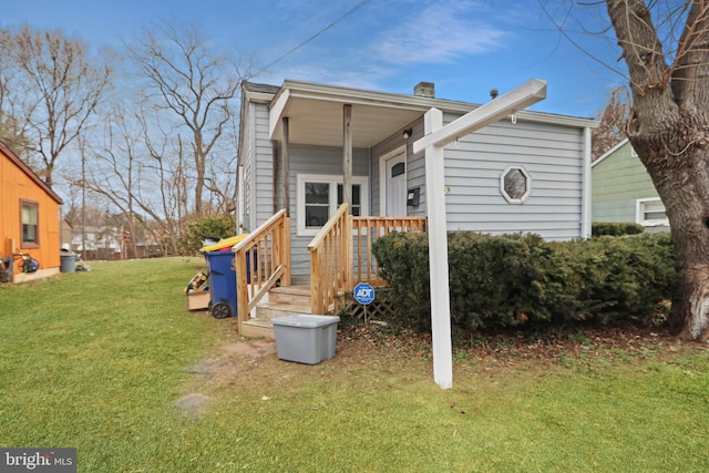 rear view of property featuring a yard and a chimney