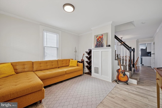 living room featuring ornamental molding, wood finished floors, visible vents, and stairs